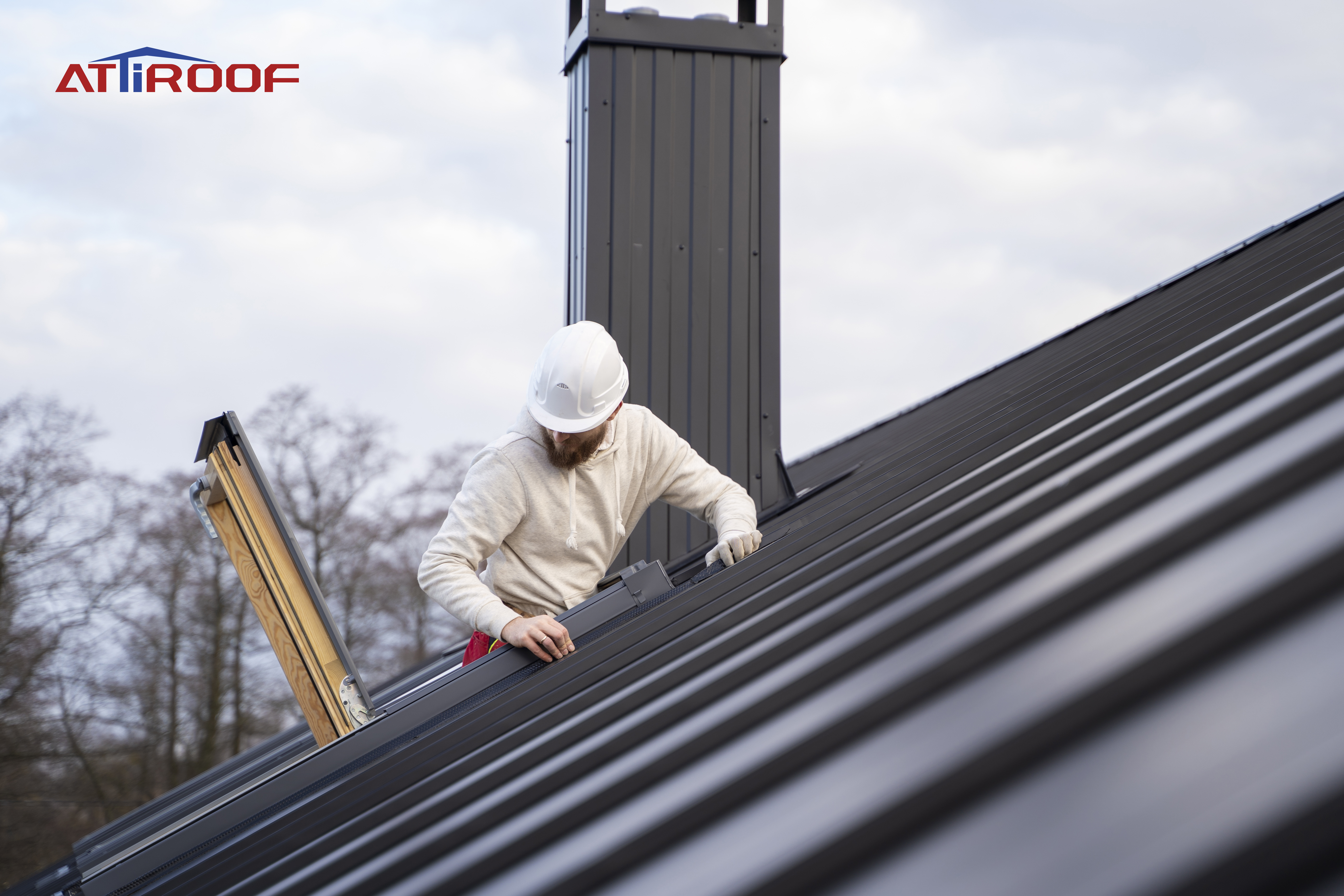 A professional examining the condition of metal roof shingles for issues such as cracks, fading, or snow accumulation.