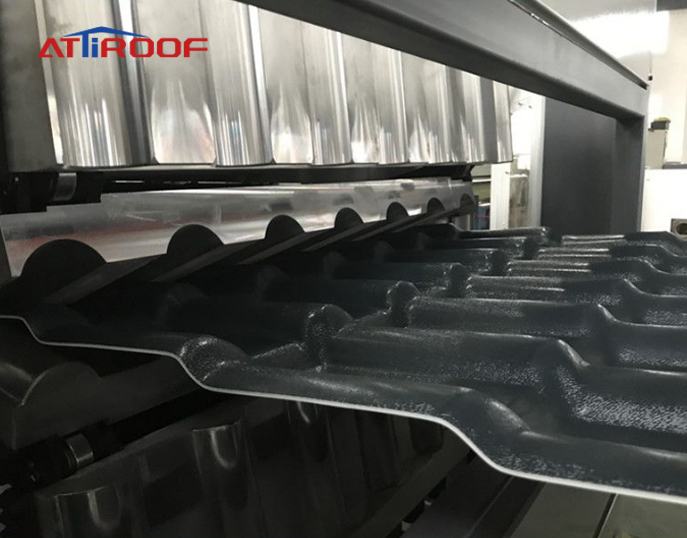 Manufacturing process of black synthetic resin roof tiles on production line machinery.