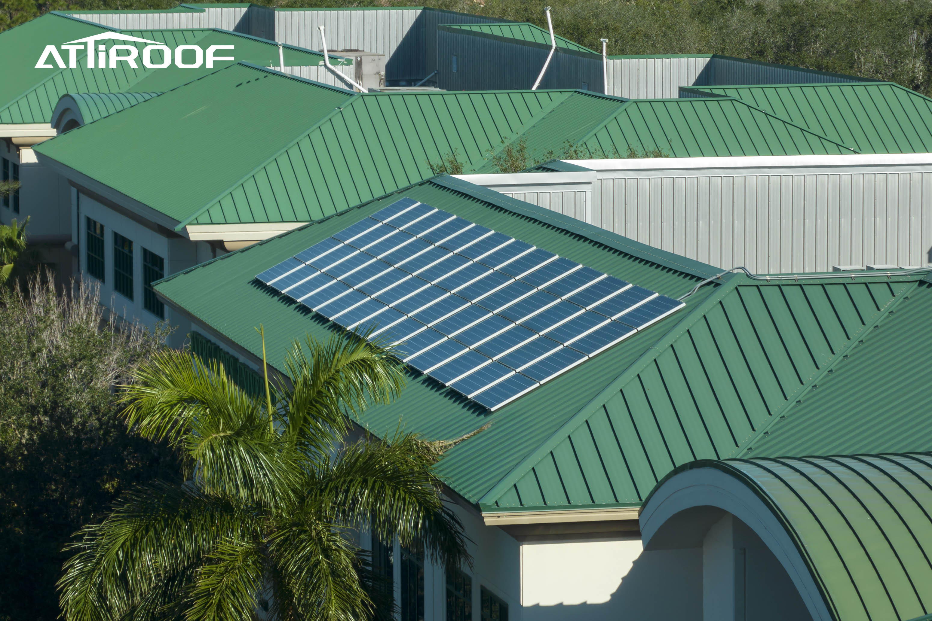 Modern roofing trend showing green synthetic resin tiles integrated with solar panels on a commercial building.