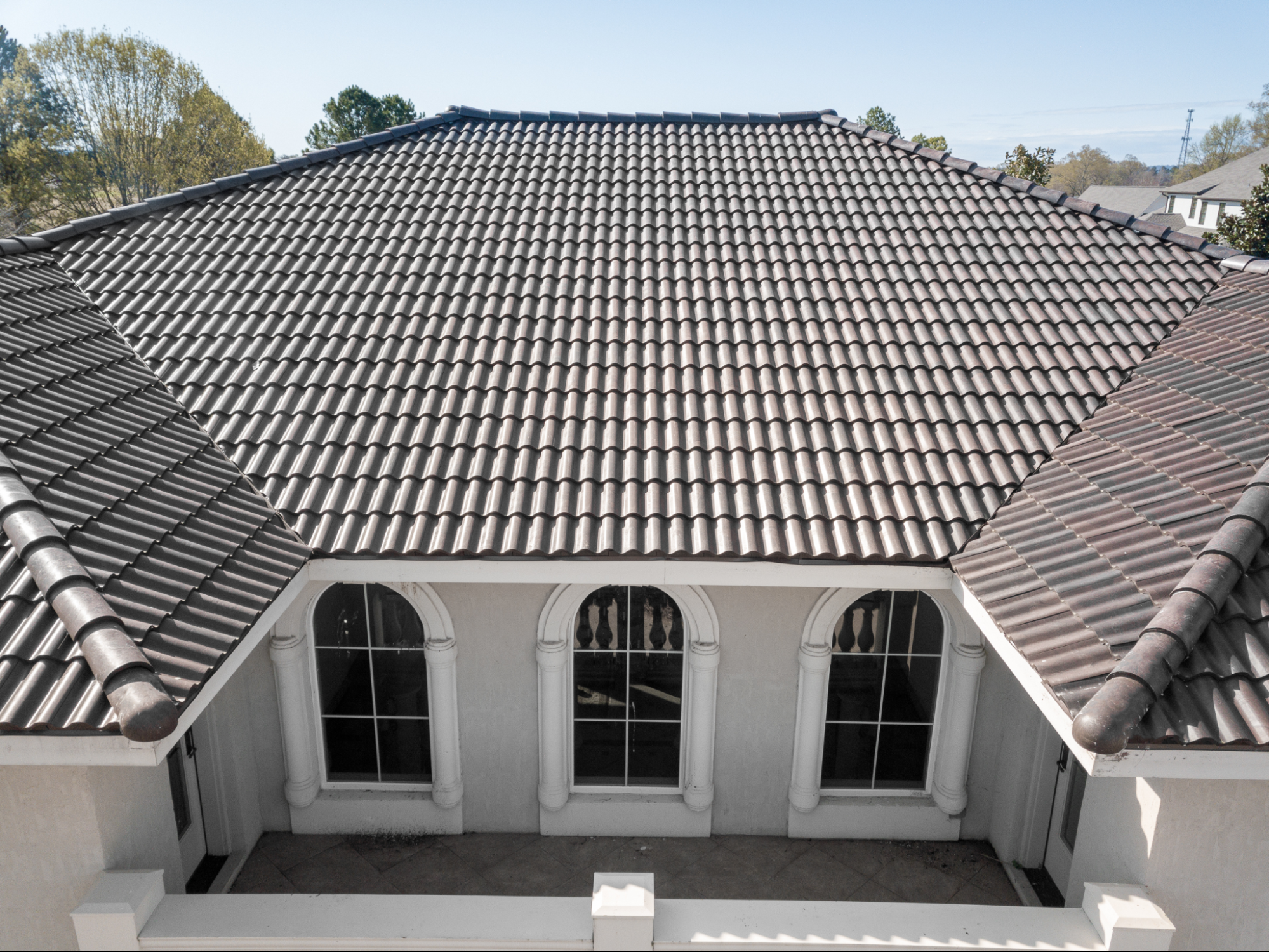 A stunning view of a villa in the Tuscan countryside, Italy, with a roof covered in dark grey resin tiles.