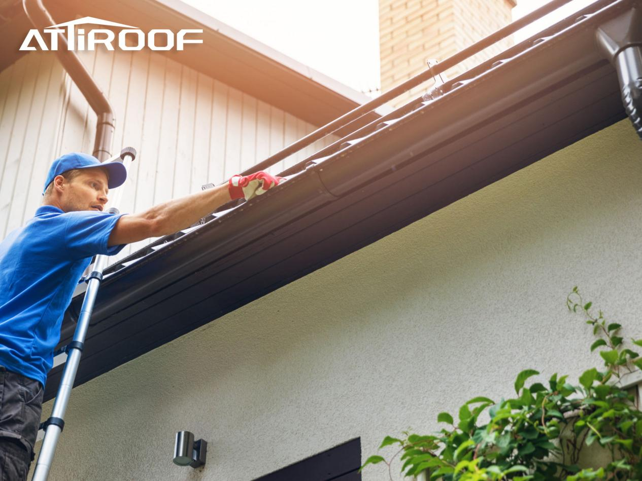 A worker use ladders to clean the drainage system on the roof.