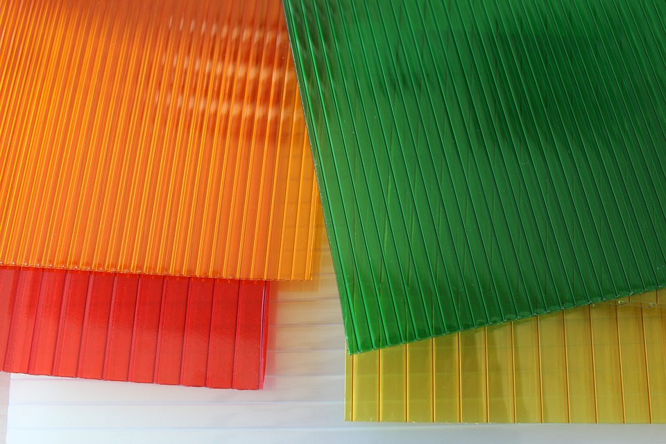 The four polycarbonate roof sheets used as clear roof panels are orange, yellow, green, and red from left to right.