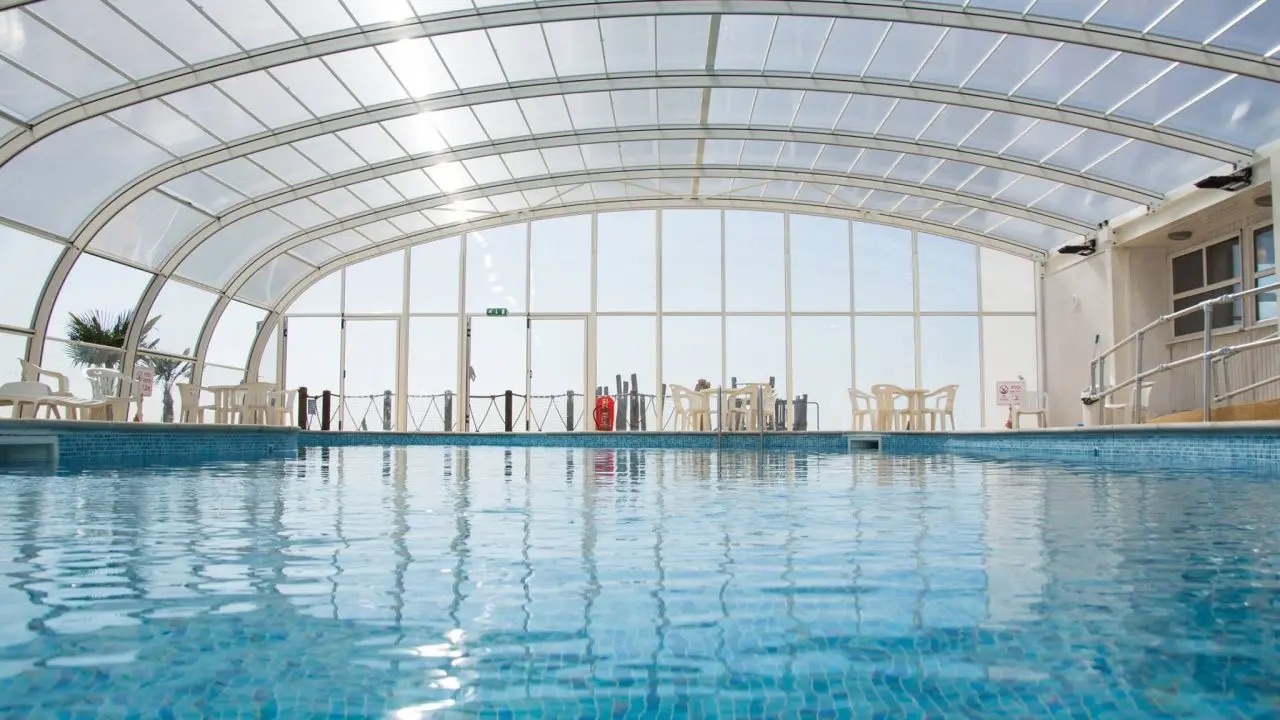 Indoor swimming pool with a transparent polycarbonate roof.